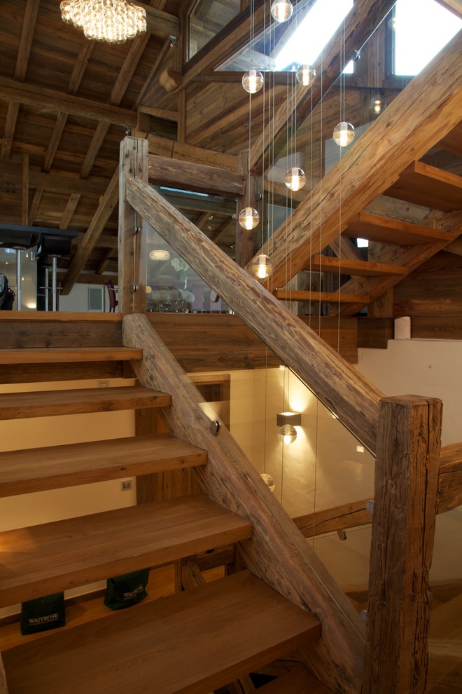Cette image montre un grand escalier sans contremarche chalet en U avec des marches en bois et éclairage.