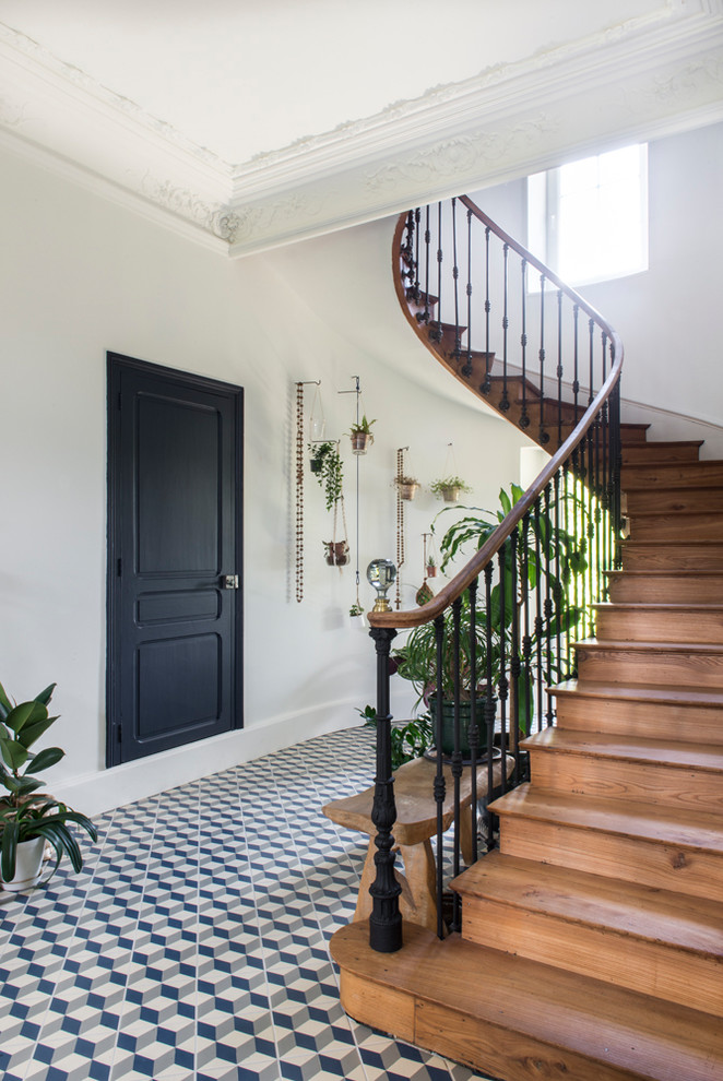 Modelo de escalera curva bohemia de tamaño medio con escalones de madera, contrahuellas de madera y barandilla de varios materiales