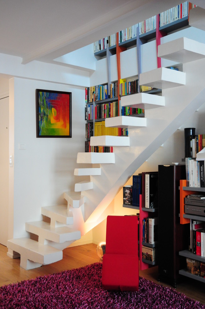 Idée de décoration pour un escalier courbe design en béton de taille moyenne avec rangements.