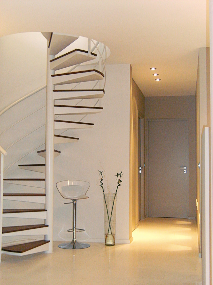 Idée de décoration pour un escalier hélicoïdal design de taille moyenne avec des marches en bois et un garde-corps en métal.