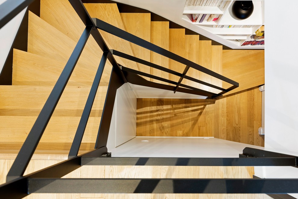 Cette image montre un escalier design avec des marches en bois, des contremarches en bois et un garde-corps en métal.
