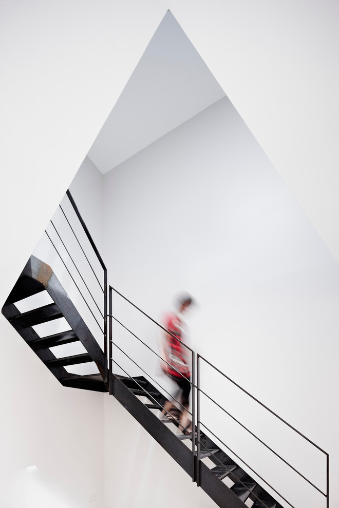 Réalisation d'un grand escalier sans contremarche courbe design avec des marches en métal.