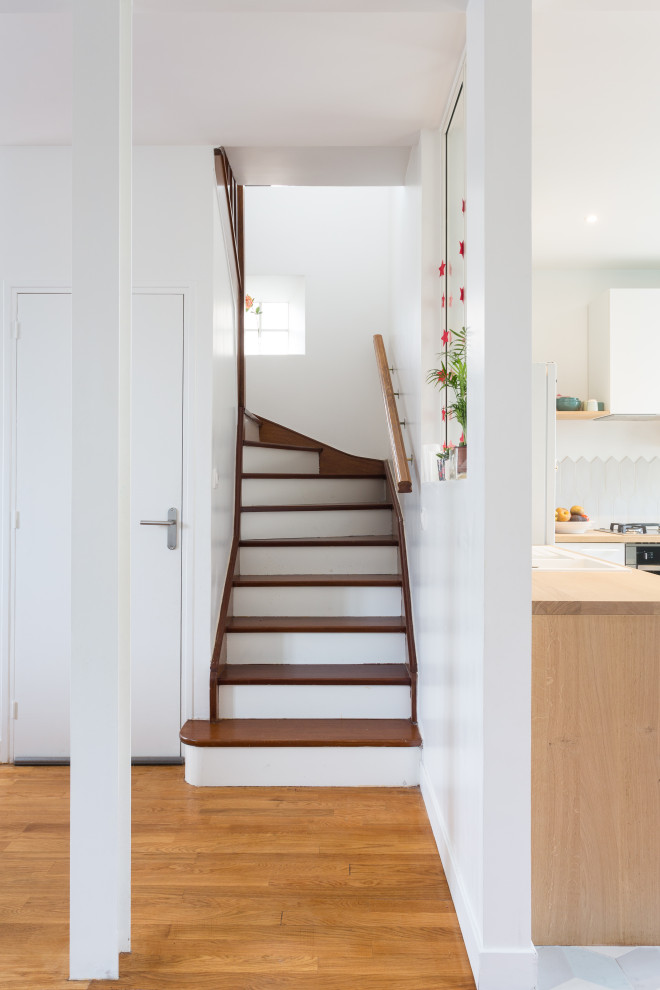 Réalisation d'un petit escalier peint courbe minimaliste avec des marches en bois et un garde-corps en bois.