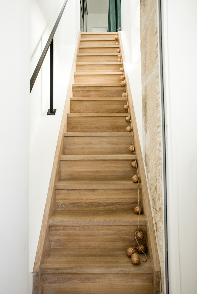 Foto de escalera recta escandinava con escalones de madera, contrahuellas de madera y barandilla de metal