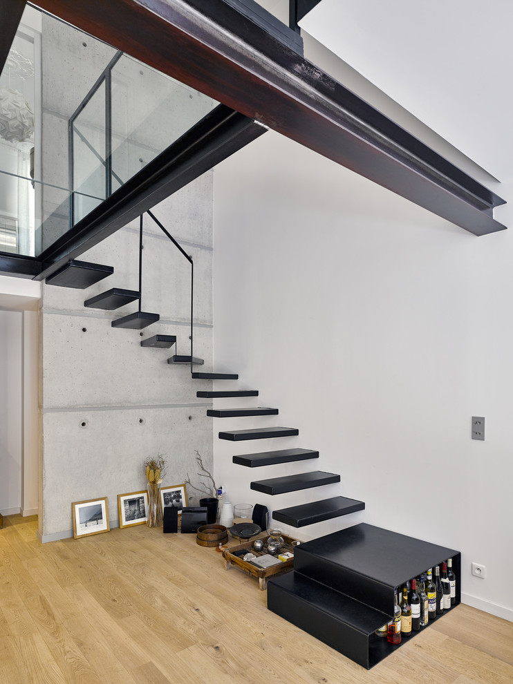 Foto de escalera suspendida contemporánea sin contrahuella con escalones de metal y barandilla de metal