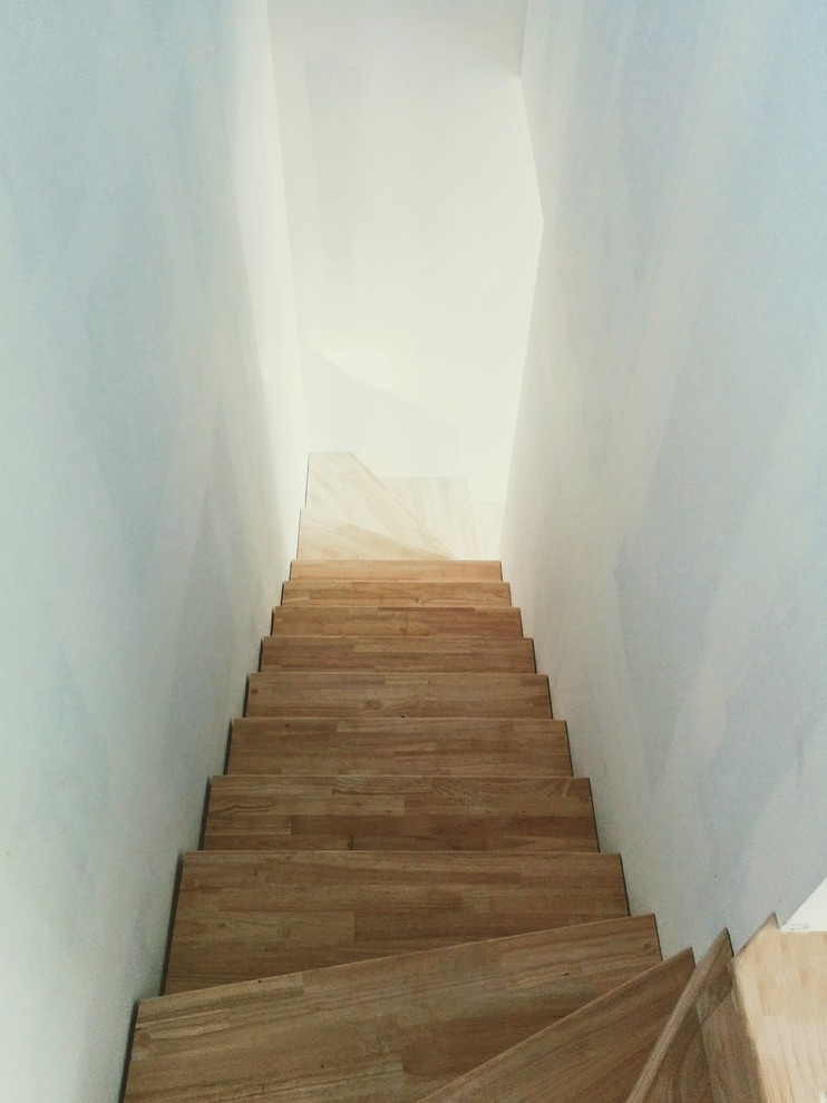 Ejemplo de escalera en U actual pequeña con escalones de madera y contrahuellas de madera