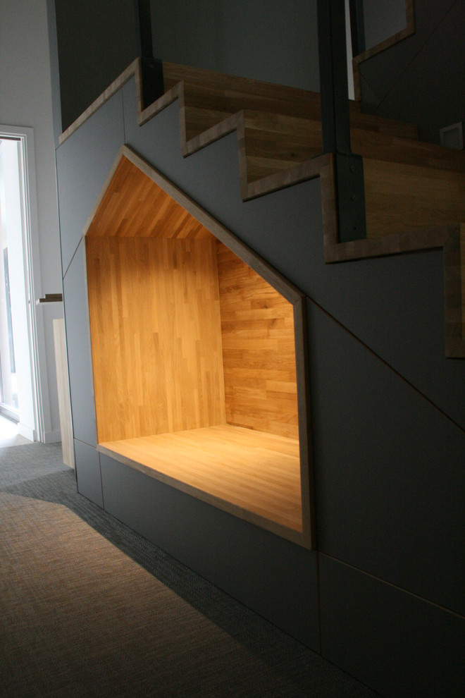 Bild på en stor funkis u-trappa i trä, med räcke i glas