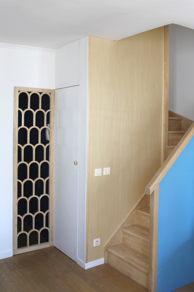 Diseño de escalera curva clásica renovada pequeña con escalones de madera, contrahuellas de madera, barandilla de varios materiales y papel pintado