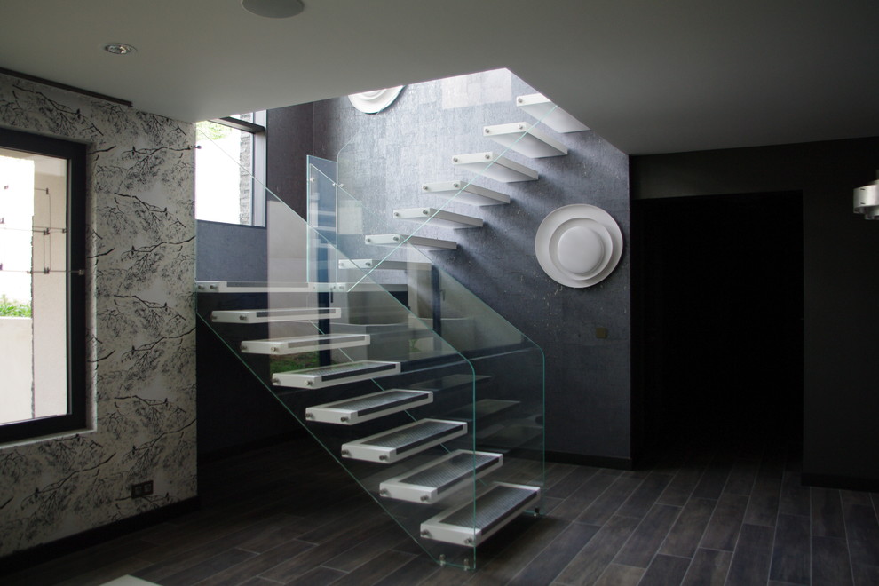 パリにあるお手頃価格の広いコンテンポラリースタイルのおしゃれな階段 (ガラスフェンス) の写真