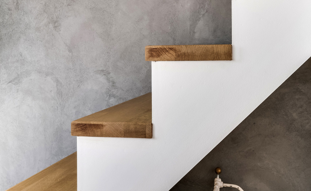 На фото: прямая лестница среднего размера в скандинавском стиле с деревянными ступенями и крашенными деревянными подступенками с