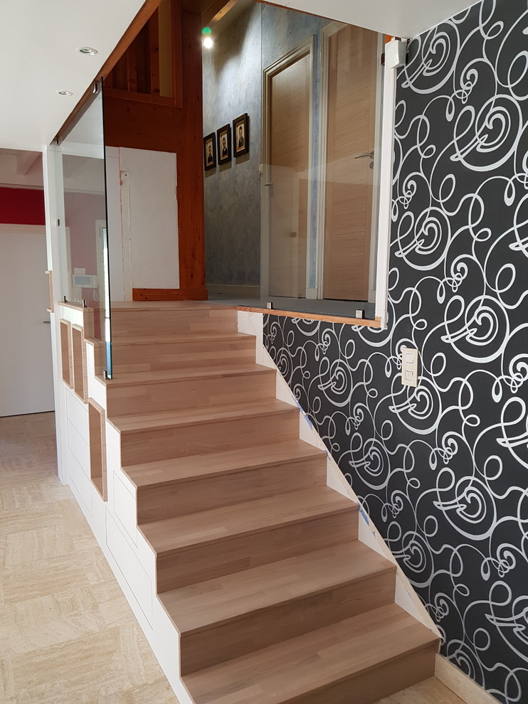 Свежая идея для дизайна: прямая деревянная лестница среднего размера в стиле модернизм с деревянными ступенями и стеклянными перилами - отличное фото интерьера