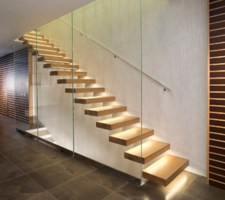На фото: прямая лестница среднего размера в современном стиле с деревянными ступенями и стеклянными перилами с