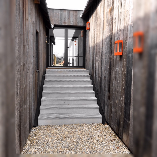 Cette photo montre un escalier droit industriel en béton et bois de taille moyenne avec des contremarches en béton et un garde-corps en bois.