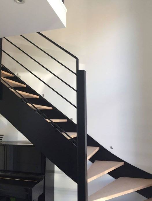 Diseño de escalera curva actual pequeña sin contrahuella con escalones de madera y barandilla de metal