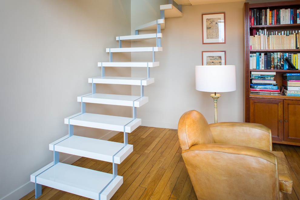 Photo of a medium sized contemporary curved staircase in Paris with feature lighting.