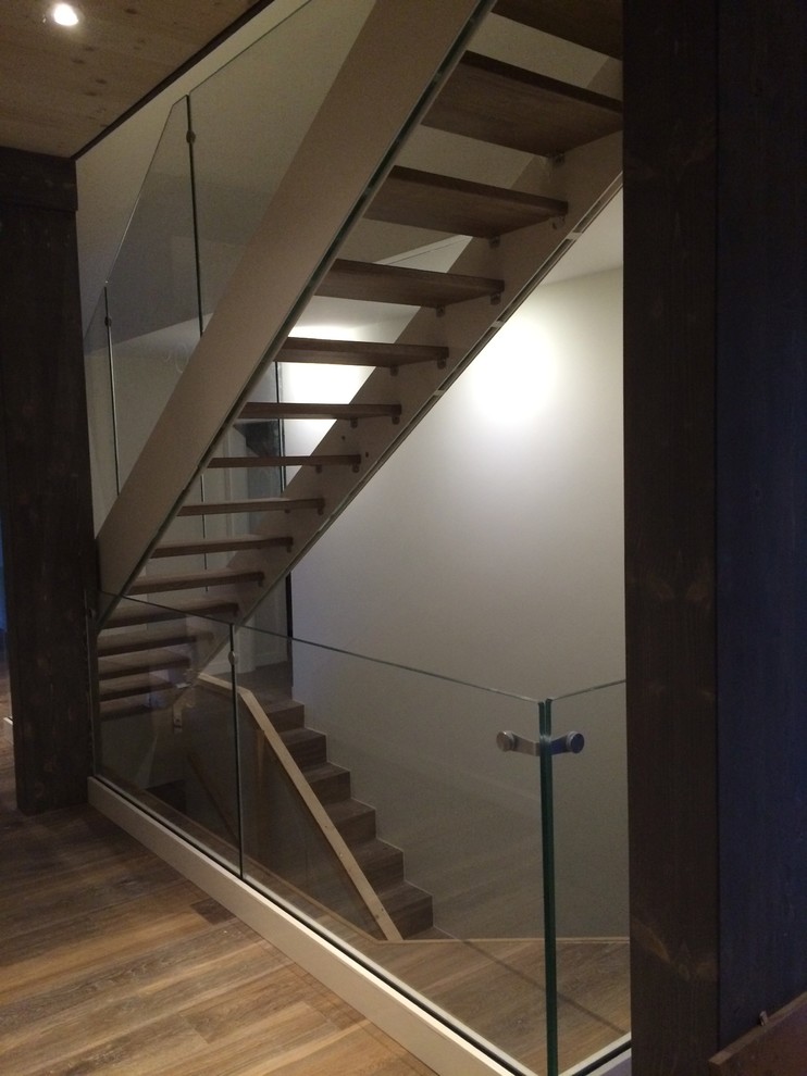 Imagen de escalera recta actual grande con escalones de madera y barandilla de vidrio