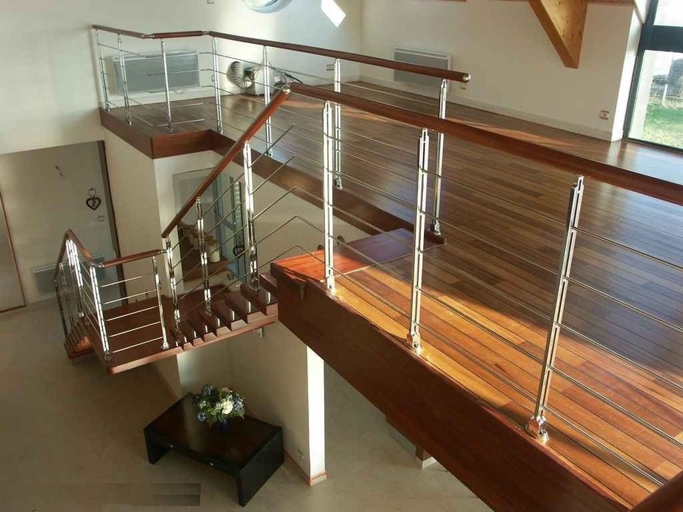 Foto di una grande scala a rampa dritta minimalista con pedata in legno, nessuna alzata e parapetto in metallo