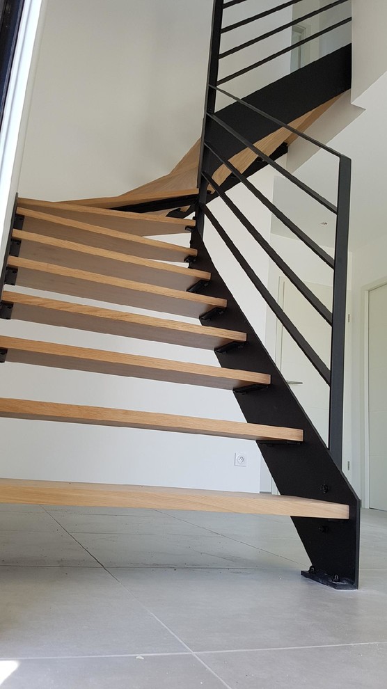 Exemple d'un escalier tendance en L avec des marches en bois.