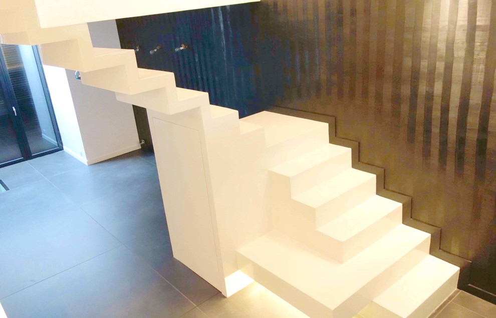 Aménagement d'un escalier contemporain en béton avec des contremarches en béton.