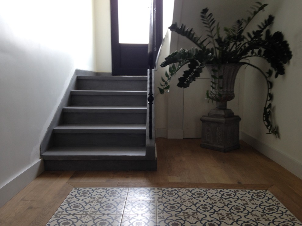 ナントにある高級な小さなインダストリアルスタイルのおしゃれな折り返し階段 (コンクリートの蹴込み板、金属の手すり) の写真