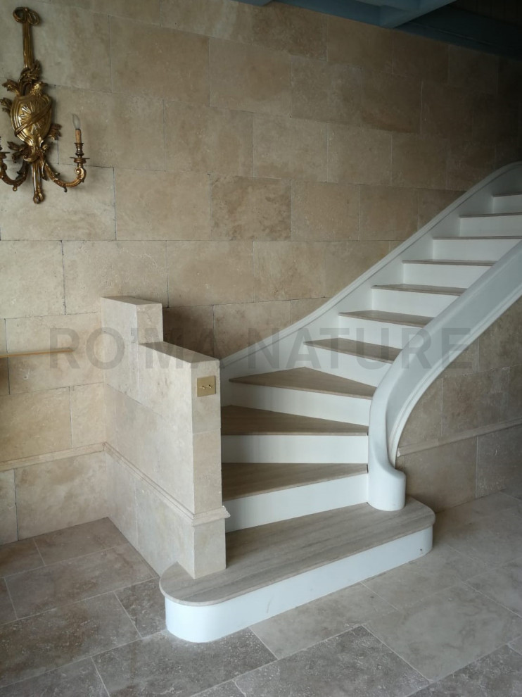 На фото: угловая лестница в классическом стиле с ступенями из травертина с