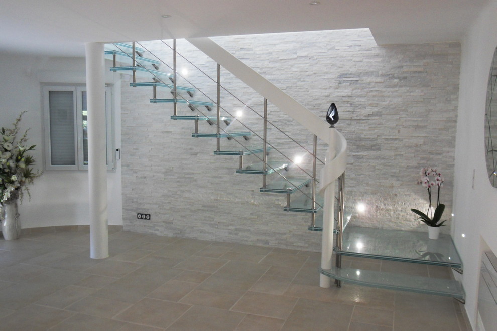 Idée de décoration pour un escalier design en L avec des marches en verre.
