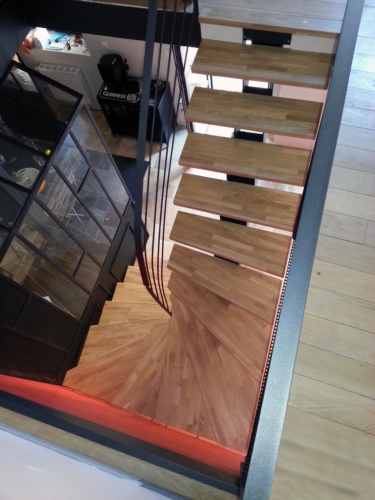 Photo of a contemporary wood curved staircase in Lyon with open risers.
