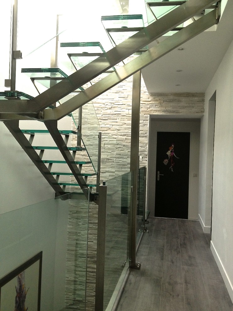 Cette photo montre un escalier sans contremarche tendance en U avec des marches en verre.