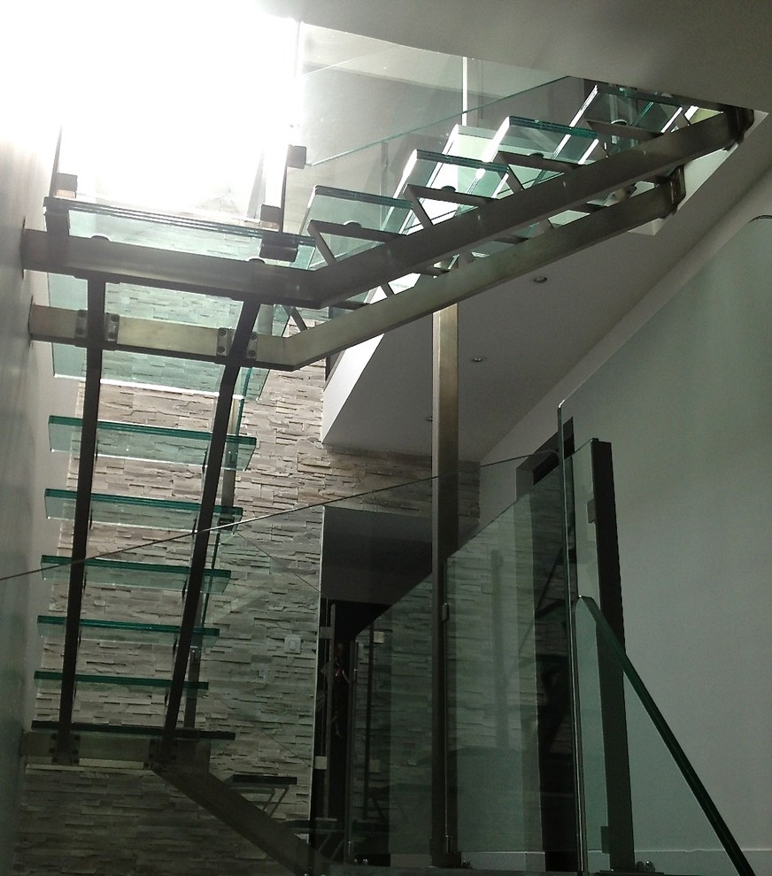 Inredning av en modern u-trappa i glas, med öppna sättsteg