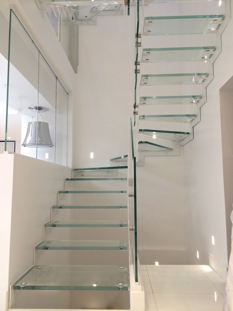 This is an example of a medium sized contemporary glass u-shaped staircase in Paris with open risers.