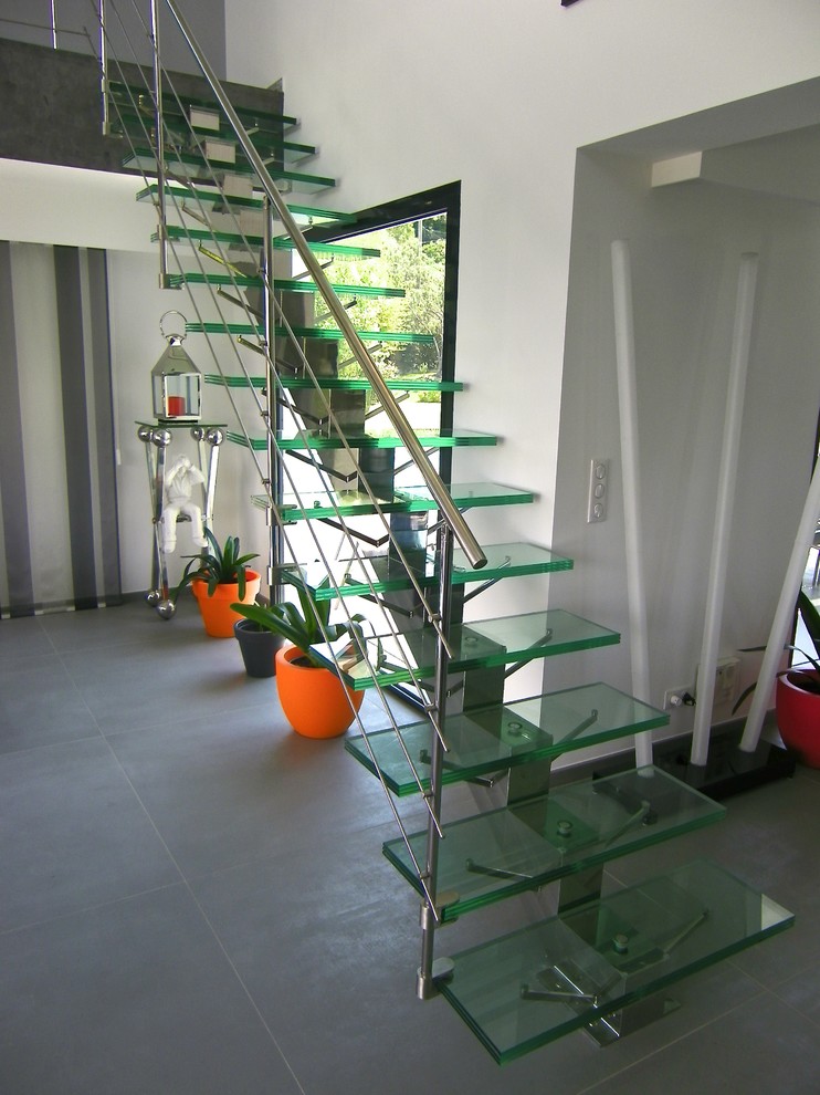 Diseño de escalera recta moderna de tamaño medio sin contrahuella con escalones de vidrio y barandilla de metal