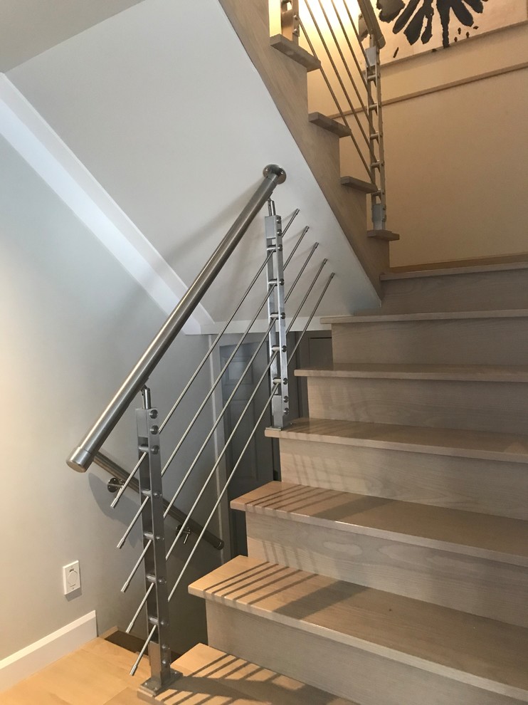 Foto de escalera en L minimalista de tamaño medio con escalones de madera, contrahuellas de madera y barandilla de metal
