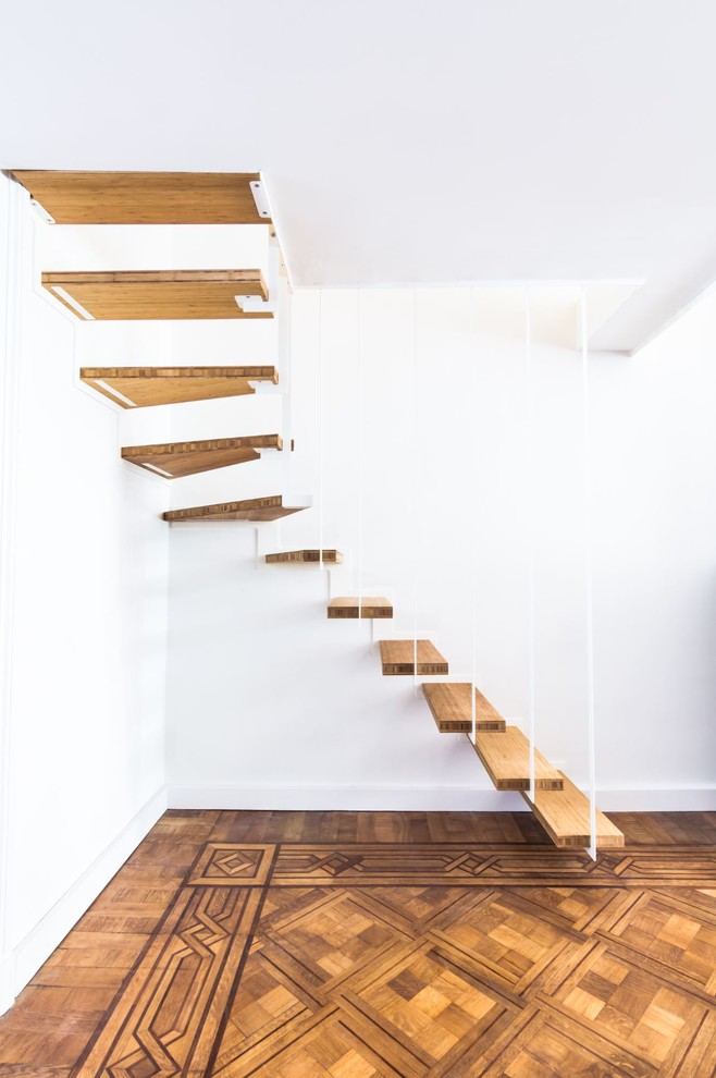 Exemple d'un escalier tendance en L avec des marches en bois et un garde-corps en métal.
