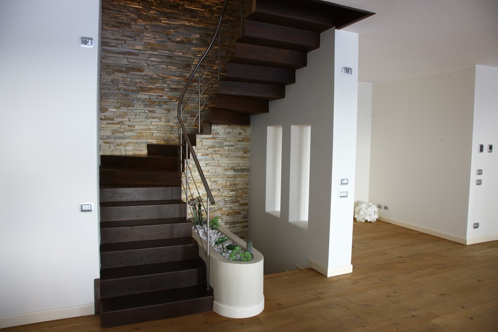 Aménagement d'un escalier courbe classique de taille moyenne avec des marches en bois, des contremarches en bois et un garde-corps en métal.
