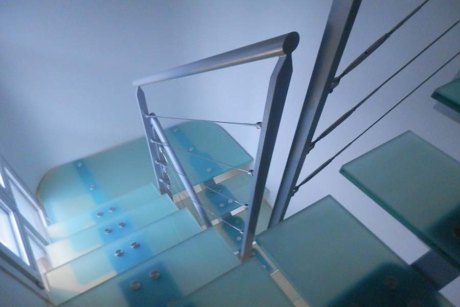 Пример оригинального дизайна: п-образная лестница среднего размера в стиле модернизм с стеклянными ступенями и перилами из тросов без подступенок