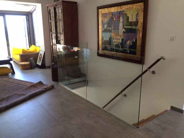 Imagen de escalera en L moderna de tamaño medio con escalones de vidrio y contrahuellas de metal