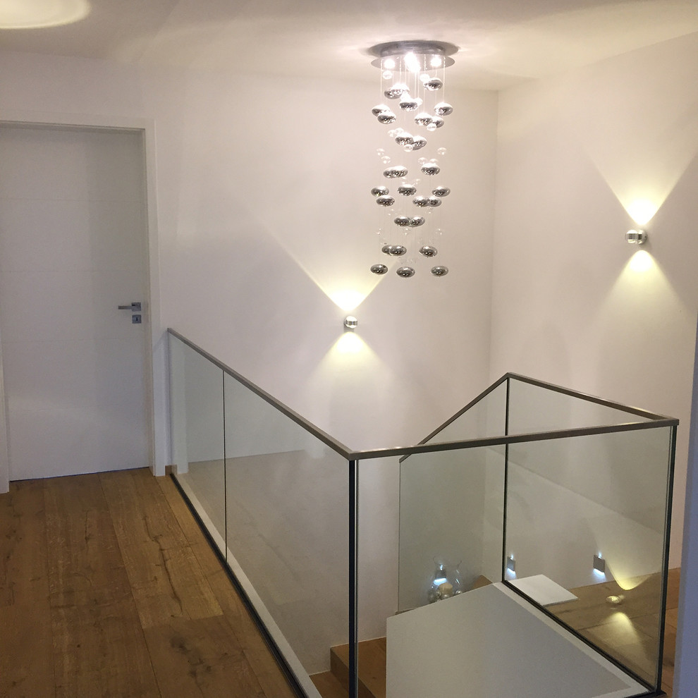 Imagen de escalera en U bohemia de tamaño medio con escalones de madera, contrahuellas de vidrio y barandilla de vidrio