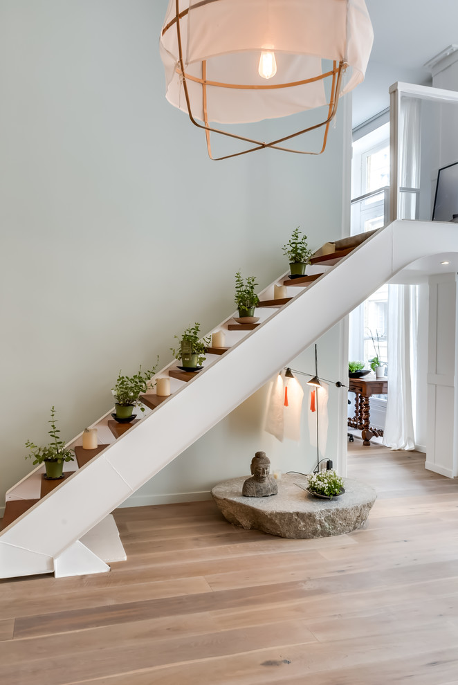 Medium sized world-inspired wood straight staircase in Paris with open risers.