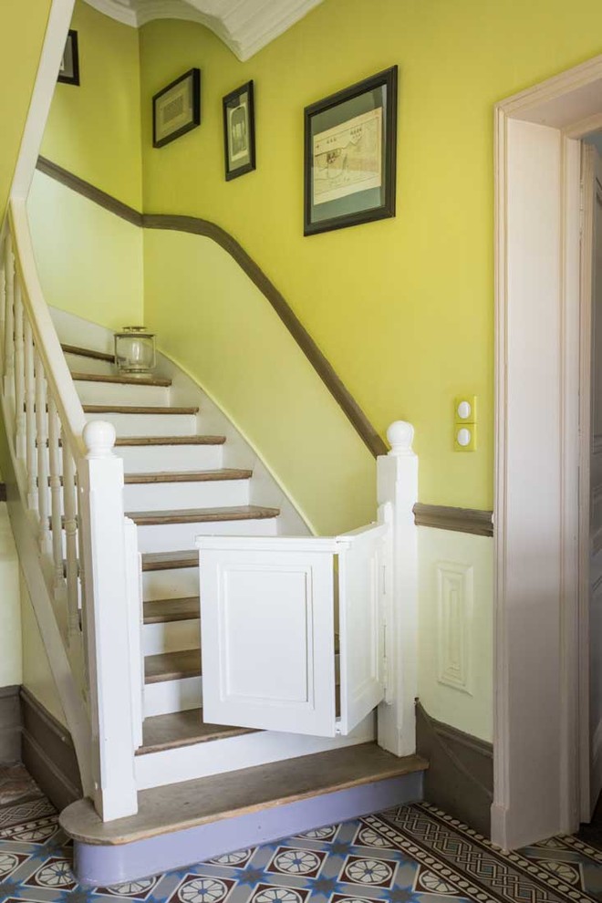 Diseño de escalera curva campestre de tamaño medio con escalones de madera y contrahuellas de madera pintada