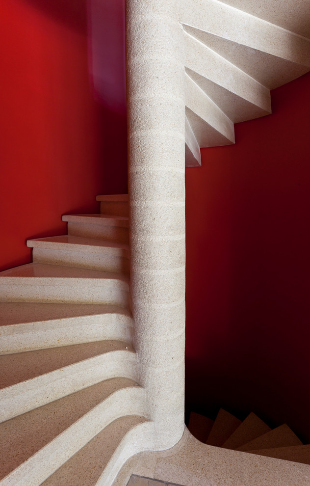 На фото: винтовая лестница среднего размера в современном стиле с ступенями из известняка, подступенками из известняка и перилами из смешанных материалов