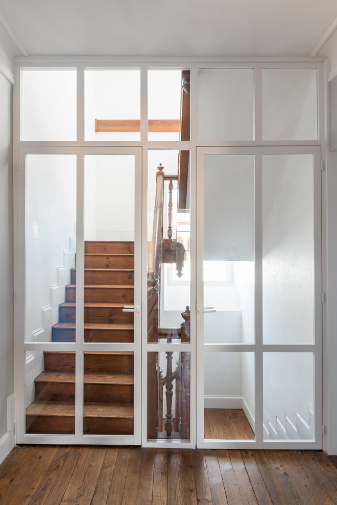 Imagen de escalera clásica con barandilla de madera, escalones de madera y contrahuellas de madera