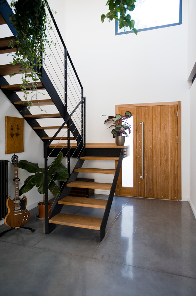This is an example of a medium sized contemporary wood u-shaped staircase in Montpellier with open risers.