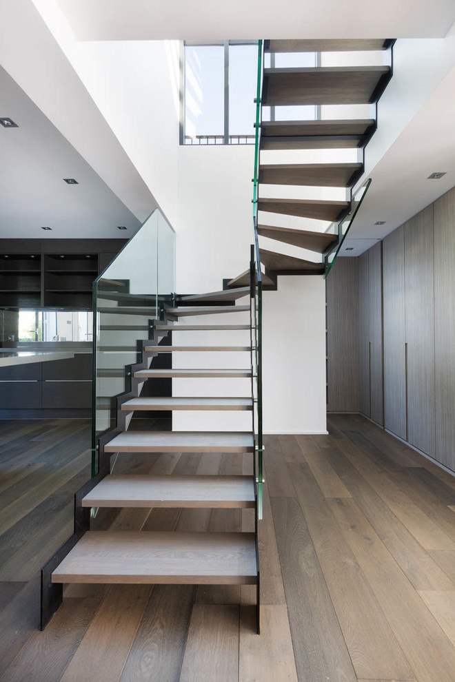 Idées déco pour un grand escalier sans contremarche courbe moderne avec des marches en bois et palier.