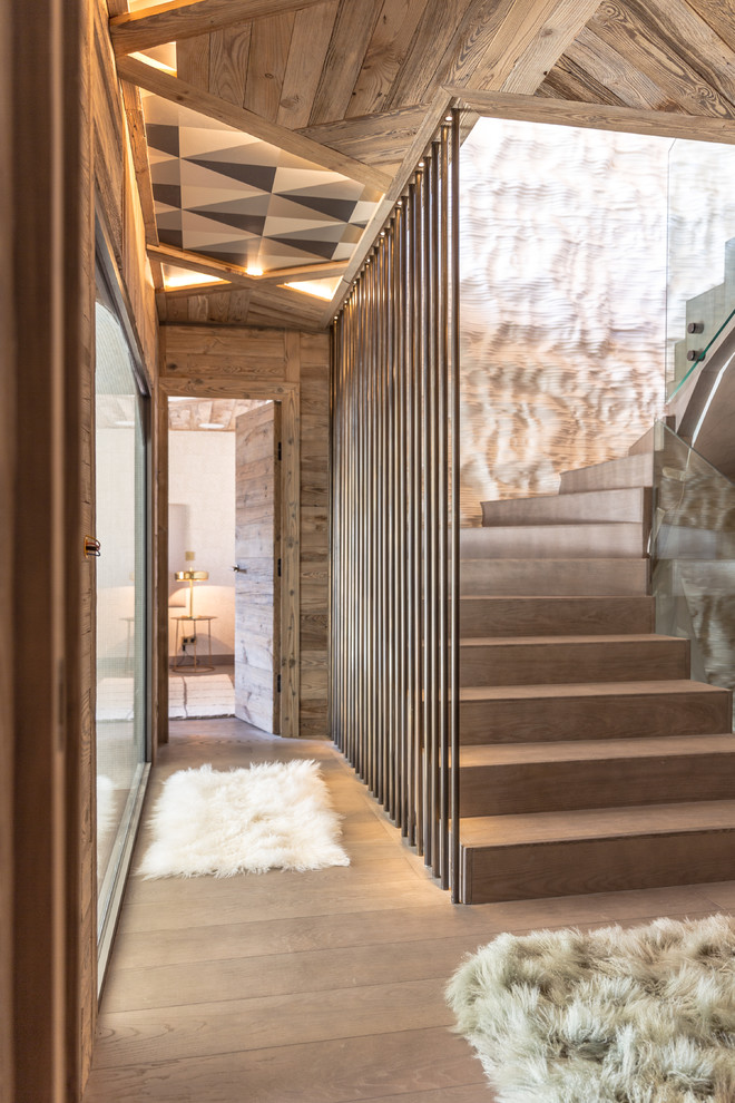 Idée de décoration pour un grand escalier courbe chalet avec des marches en bois et des contremarches en bois.