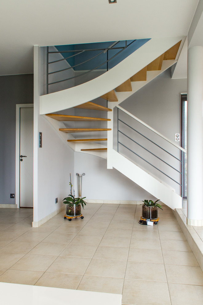 Idées déco pour un escalier contemporain en U de taille moyenne avec des marches en bois peint et un garde-corps en métal.