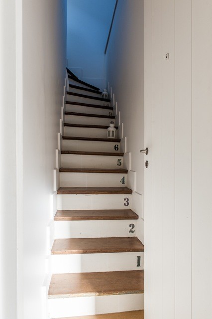 Photo of a small contemporary wood l-shaped staircase in Paris with wood risers.