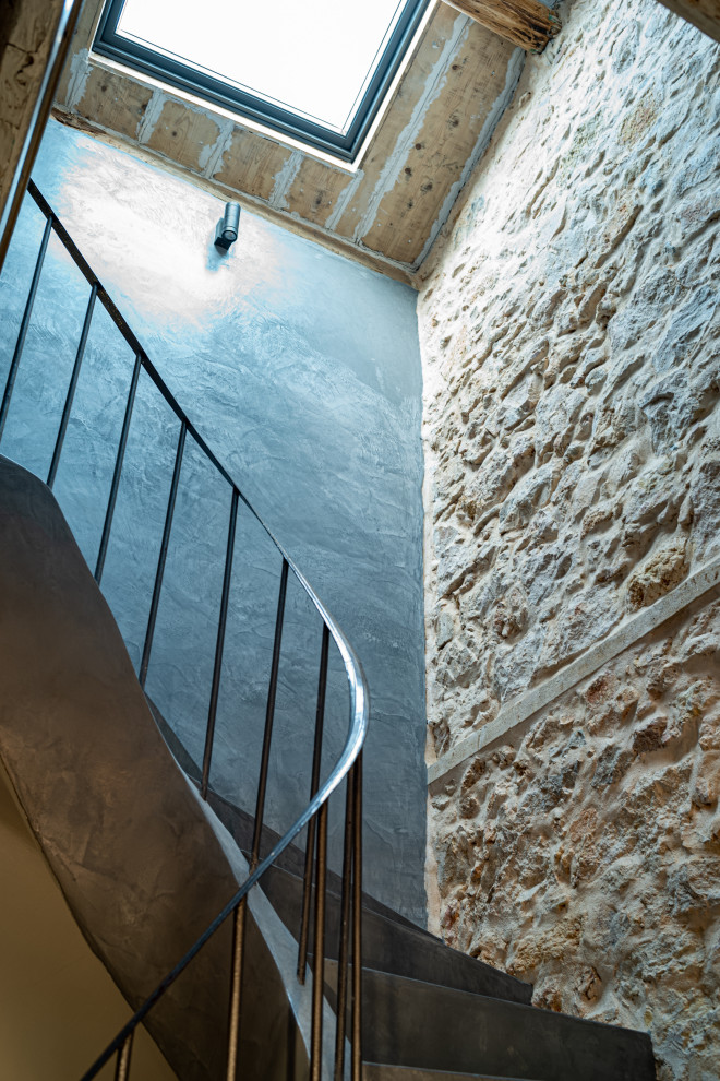 ニースにある低価格の小さな地中海スタイルのおしゃれなサーキュラー階段 (コンクリートの蹴込み板、金属の手すり) の写真