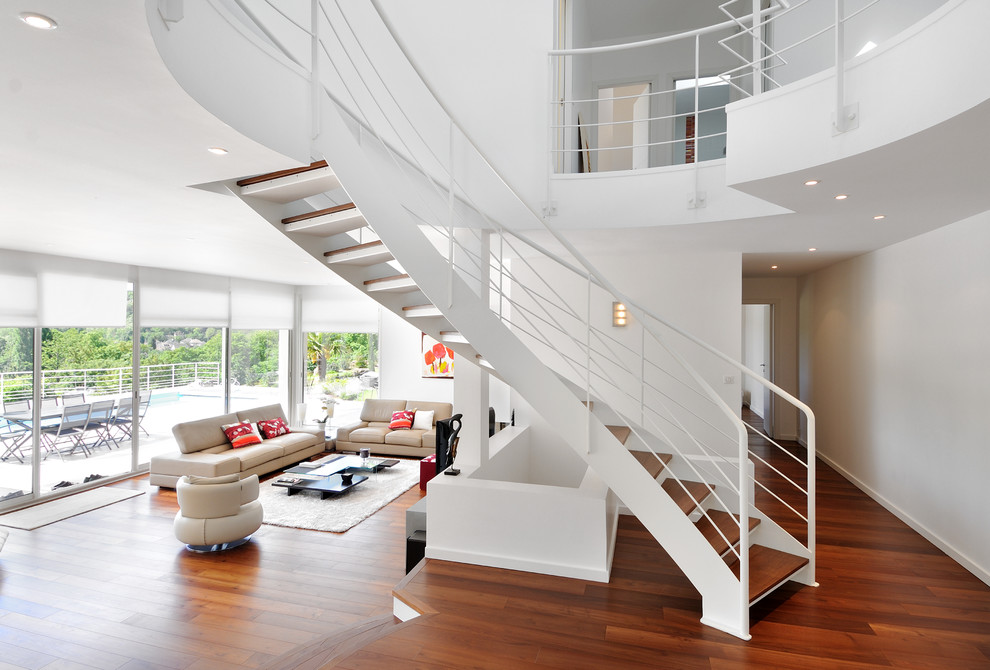 На фото: большая изогнутая лестница в стиле модернизм с деревянными ступенями без подступенок с