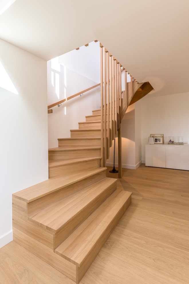 Medium sized contemporary wood curved wood railing staircase in Lyon with wood risers.