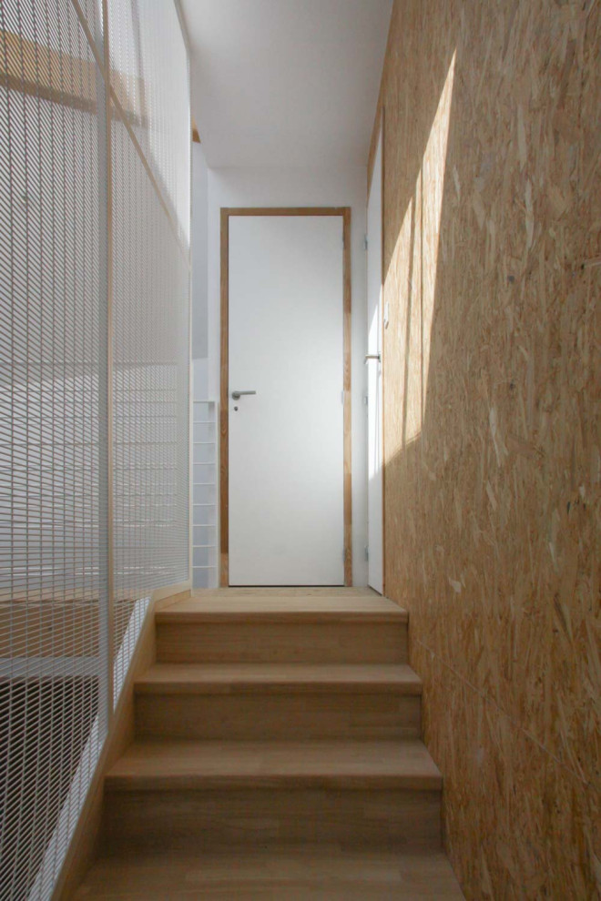 На фото: п-образная деревянная лестница среднего размера в современном стиле с деревянными ступенями, металлическими перилами и деревянными стенами